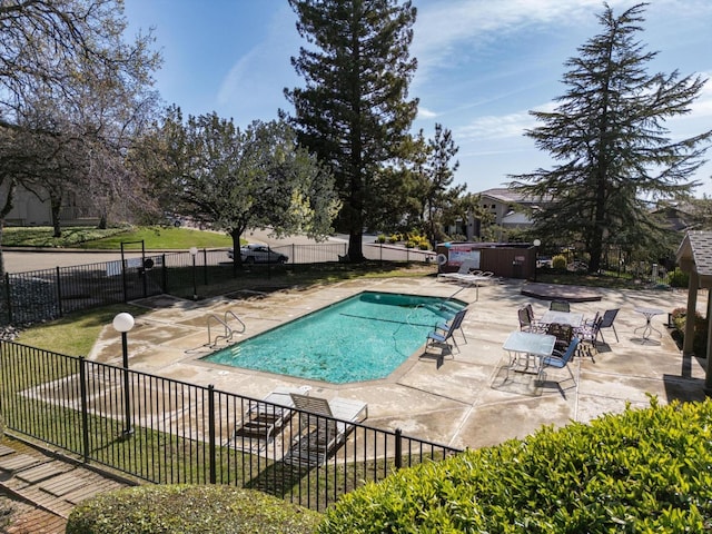 community pool featuring a jacuzzi, a patio area, and fence