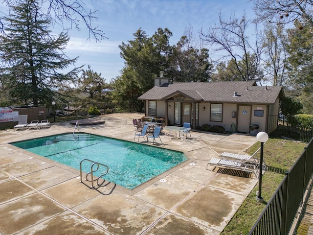 pool with a patio area and fence