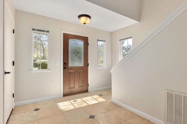entryway with light tile patterned floors, baseboards, and visible vents