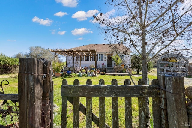 view of yard with a fenced front yard and a pergola