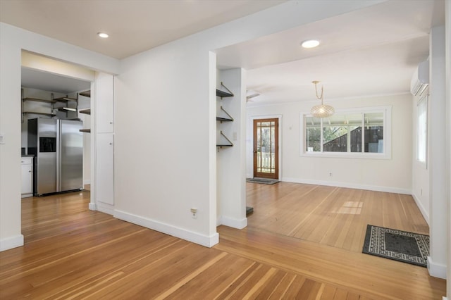 hallway with a wall mounted air conditioner, baseboards, hardwood / wood-style floors, and recessed lighting