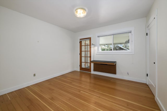 unfurnished room with light wood finished floors and baseboards