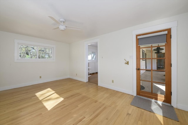 interior space with light wood-style flooring, baseboards, and a ceiling fan