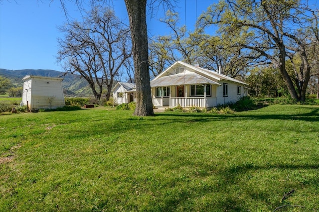 view of yard featuring a porch and a mountain view