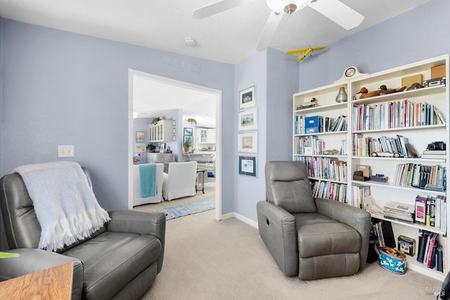 sitting room with carpet flooring, a ceiling fan, and baseboards