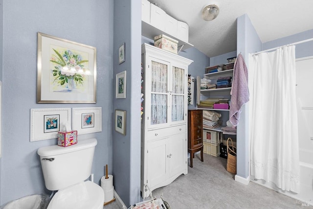 bathroom featuring toilet and shower / tub combo with curtain