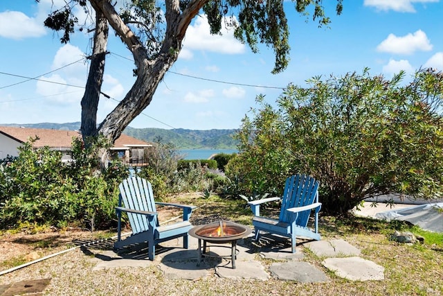 view of yard with a mountain view, a patio area, and an outdoor fire pit