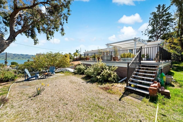 view of yard featuring stairway, a deck with mountain view, a pergola, and an outdoor fire pit