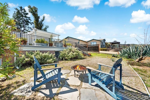 view of patio with stairs, a wooden deck, and an outdoor fire pit