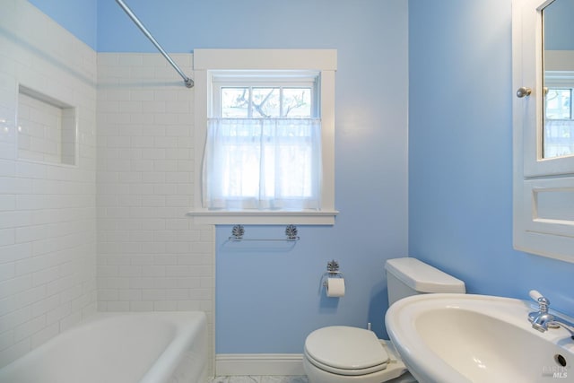 full bath featuring baseboards, a sink, toilet, and tub / shower combination