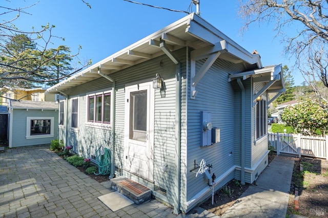 view of property exterior featuring a patio area and fence