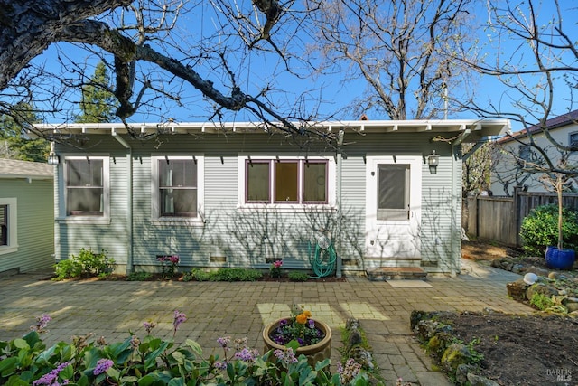 exterior space featuring entry steps, fence, and a patio