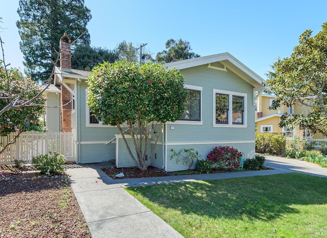 view of front of home with a front yard and fence