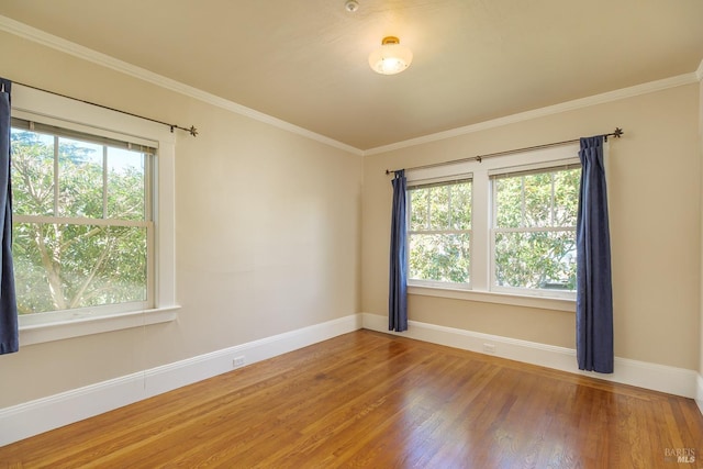 unfurnished room with ornamental molding, a healthy amount of sunlight, and wood finished floors