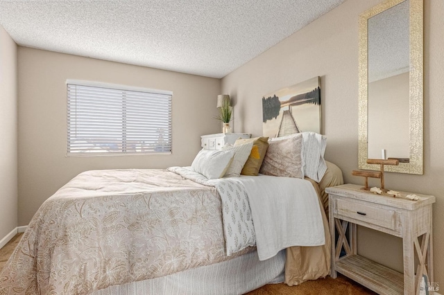 bedroom with carpet, a textured ceiling, and baseboards