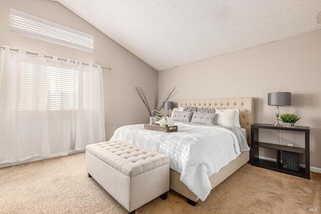 bedroom featuring vaulted ceiling, a textured ceiling, and carpet flooring