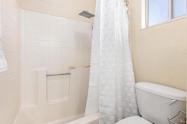 bathroom featuring shower / bathtub combination with curtain and toilet