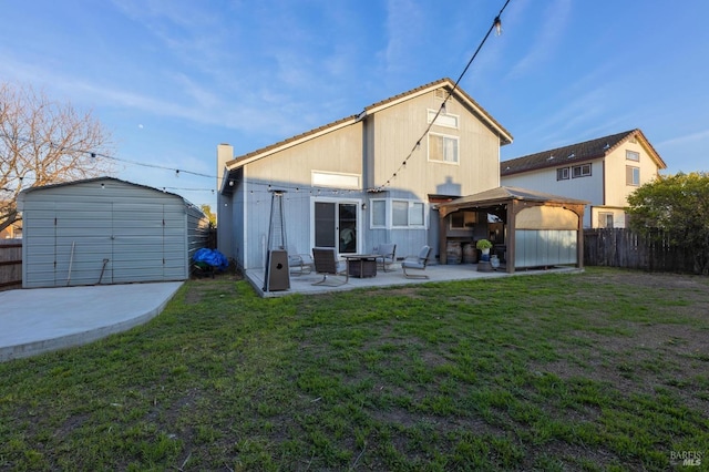 rear view of house with a fenced backyard, a gazebo, a patio area, a lawn, and a shed