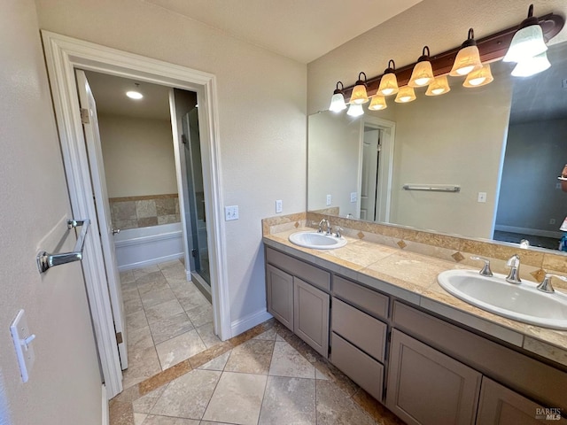 bathroom with double vanity, a shower stall, baseboards, and a sink