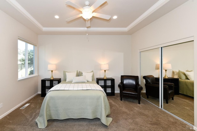 bedroom with baseboards, visible vents, a tray ceiling, carpet flooring, and a closet