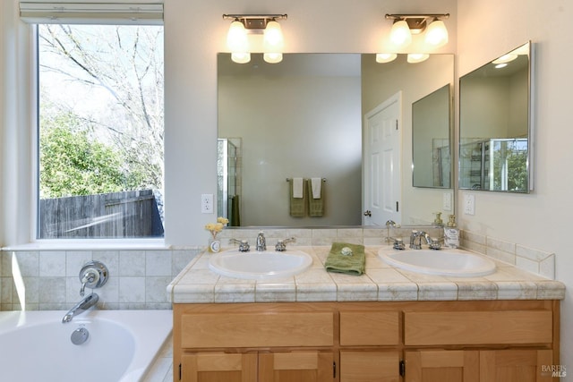 full bath with a garden tub, a sink, and double vanity