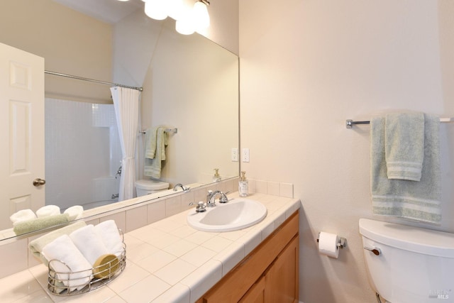 bathroom with curtained shower, vanity, and toilet