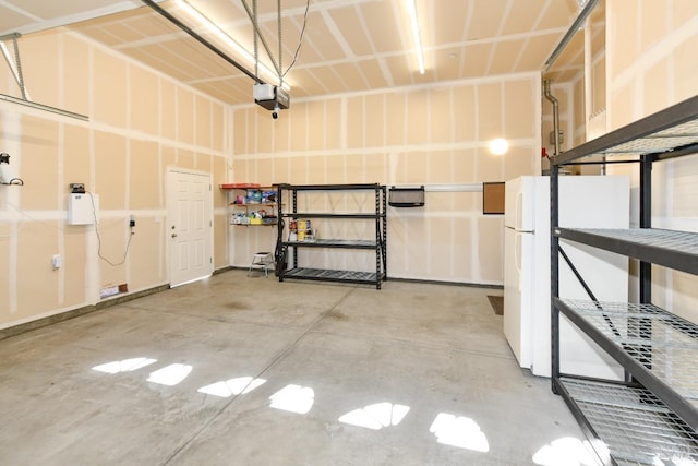 garage with freestanding refrigerator and a garage door opener