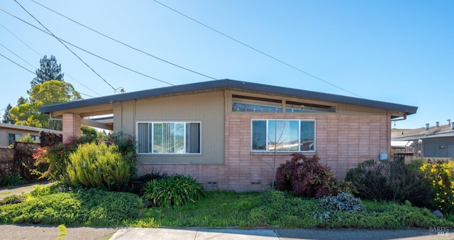 view of property exterior featuring crawl space and brick siding