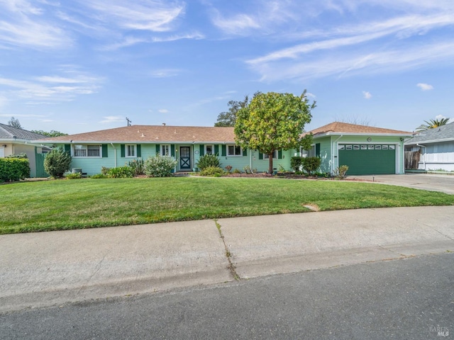 ranch-style home featuring an attached garage, concrete driveway, and a front yard