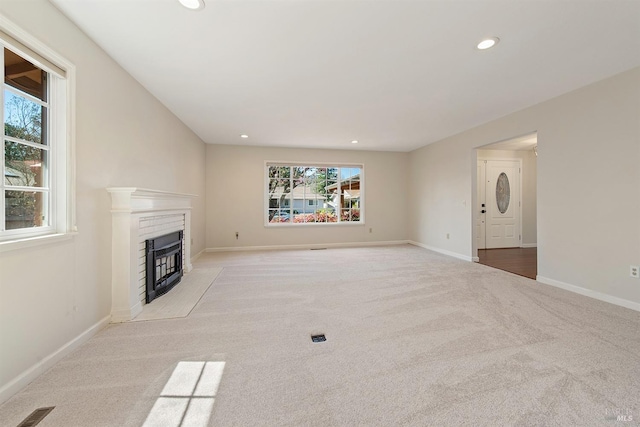 unfurnished living room featuring visible vents, recessed lighting, a fireplace, carpet flooring, and baseboards