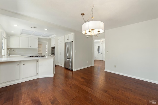 kitchen with dark wood-type flooring, stainless steel appliances, a peninsula, light countertops, and baseboards