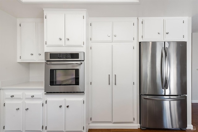 kitchen with white cabinets, appliances with stainless steel finishes, and light countertops