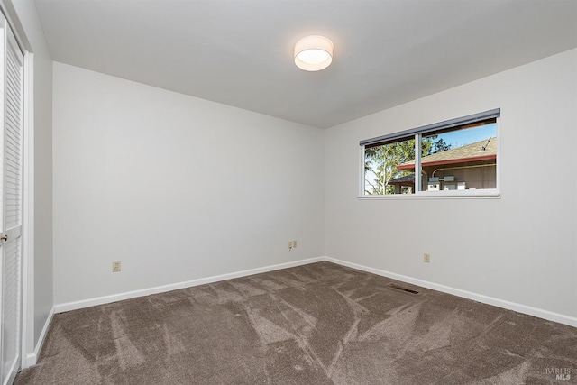 carpeted empty room with visible vents and baseboards