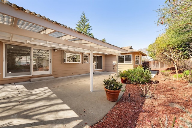 back of property featuring a patio and fence