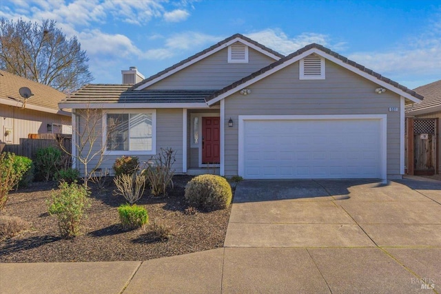 view of front facade with a tiled roof, concrete driveway, a garage, and fence