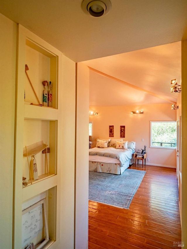 bedroom with vaulted ceiling and hardwood / wood-style flooring