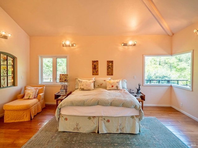 bedroom featuring lofted ceiling with beams, baseboards, and hardwood / wood-style floors