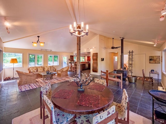 dining area with vaulted ceiling, a wood stove, and a healthy amount of sunlight