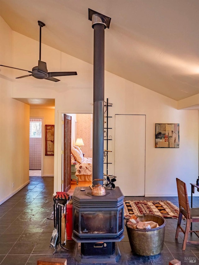 room details with baseboards, ceiling fan, and a wood stove