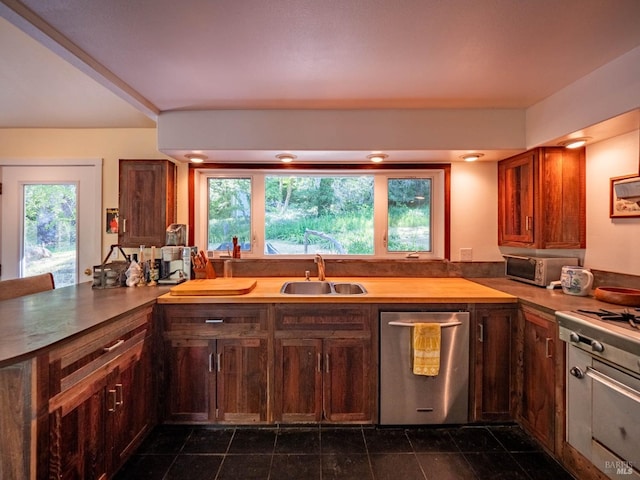 kitchen featuring dishwasher, light countertops, and a sink