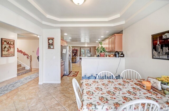 dining space featuring a tray ceiling, stairway, light tile patterned floors, and recessed lighting