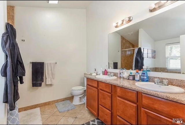 bathroom with a sink, double vanity, a shower stall, and tile patterned floors