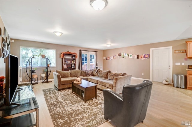 living area featuring baseboards and light wood-type flooring