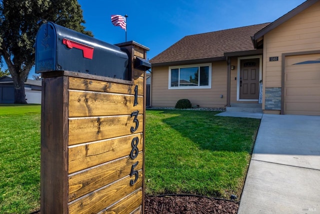 view of front of property with a front yard, a garage, and a shingled roof