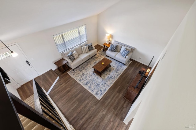 living room featuring stairway, baseboards, and wood finished floors