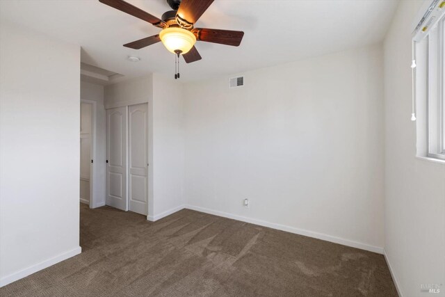 empty room with visible vents, ceiling fan, baseboards, and carpet