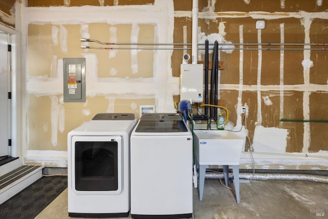 clothes washing area with electric panel, independent washer and dryer, laundry area, and a sink