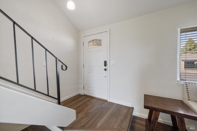 foyer featuring wood finished floors, baseboards, and vaulted ceiling