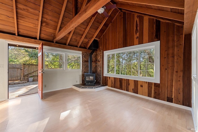 unfurnished sunroom featuring wooden ceiling, a wood stove, and vaulted ceiling with beams