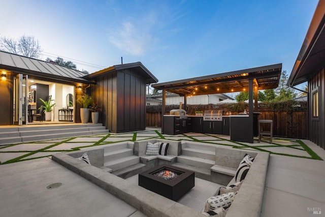 view of patio featuring a grill, area for grilling, an outdoor living space with a fire pit, an outbuilding, and fence